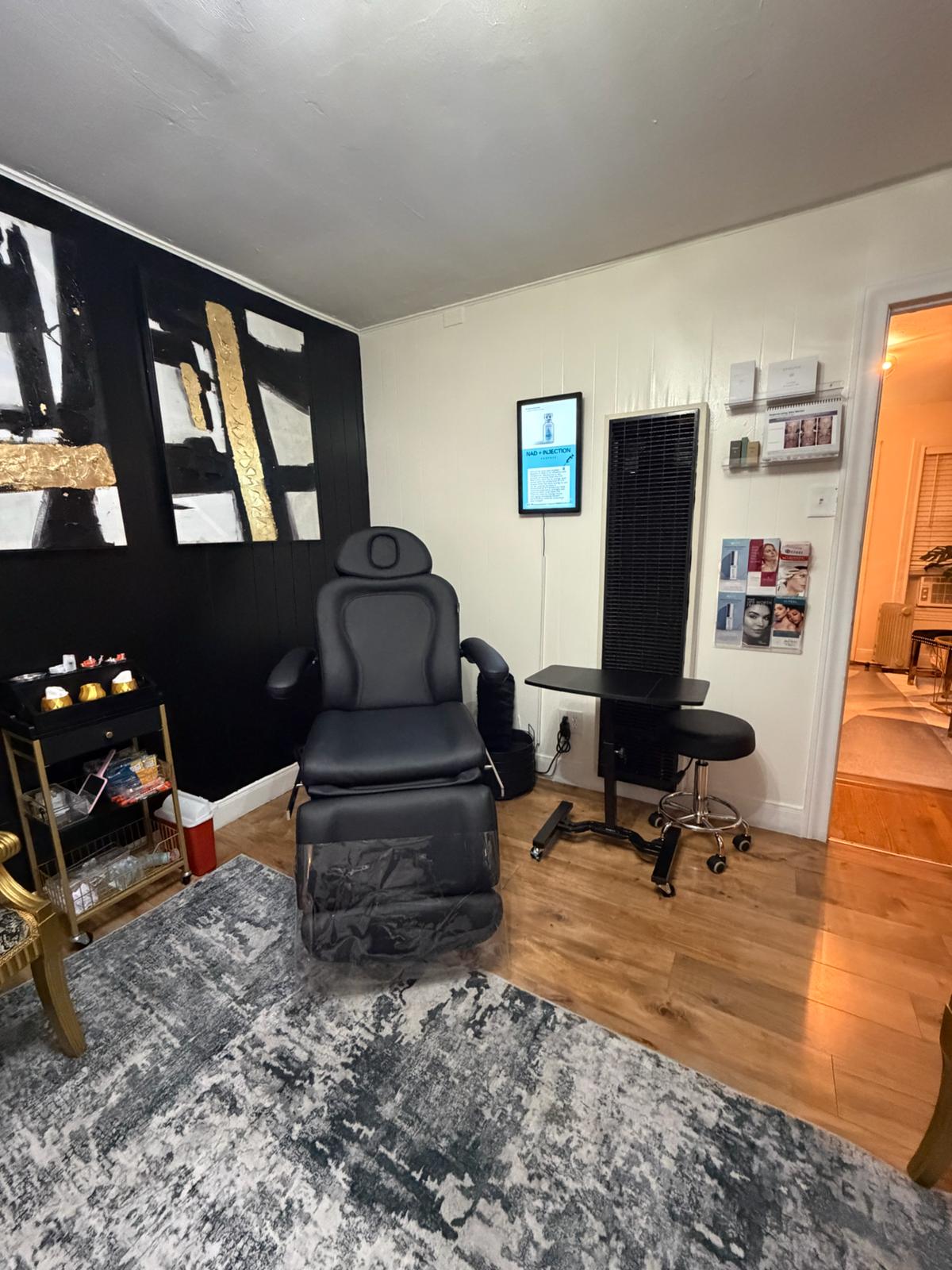 Room with a massage chair, TV, and various decor items on a wooden floor.