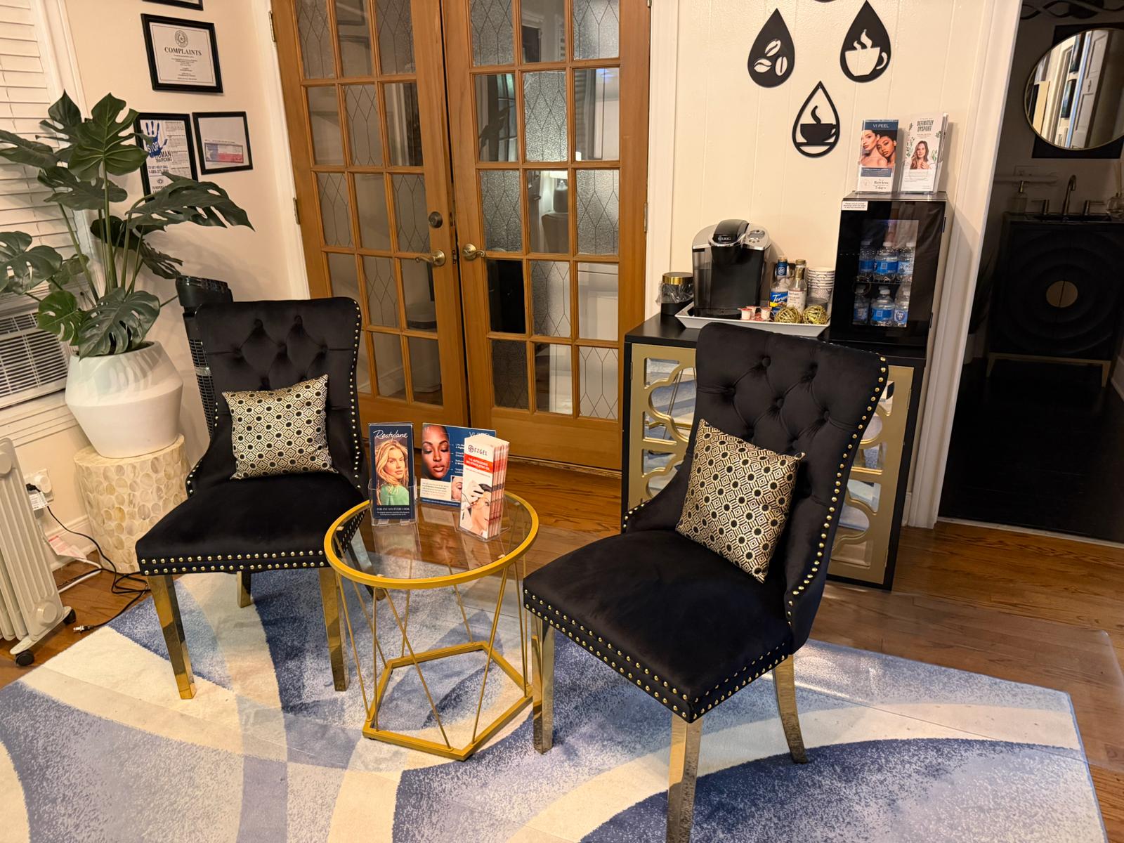 Two black chairs with patterned cushions in a room with a glass table and decor items.